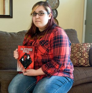 Woodland Regional High School sophomore Kaylee Velez, 16, holds a copy of ‘Deathly Pale’ by Anthony Paolucci in her home May 1. Velez created the illustrations for the book. Velez and Paolucci will be signing copies of the book from 11 a.m. until 1 p.m. Saturday at the Beacon Falls Public Library. –LUKE MARSHALL 